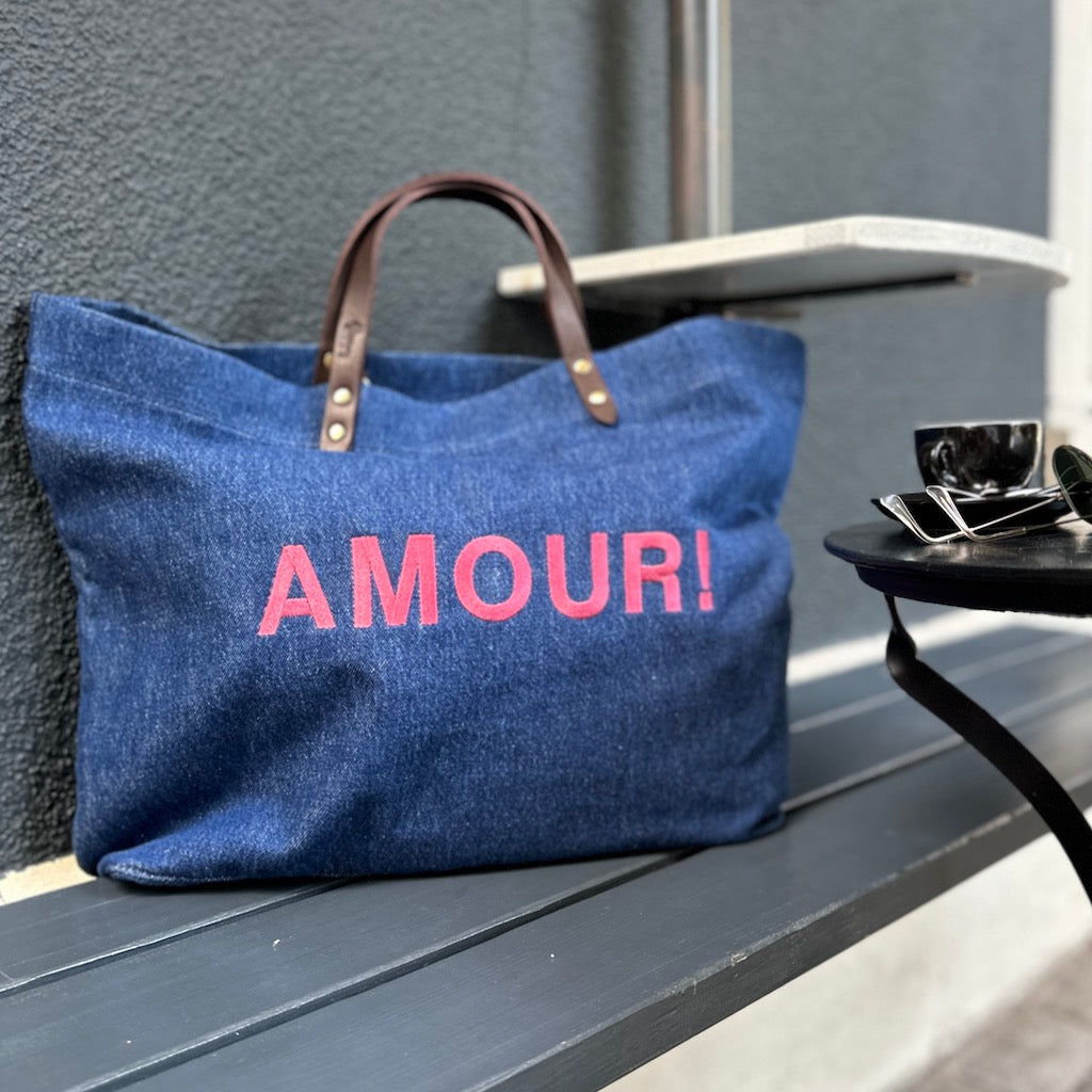 Bestickte Stofftasche von LABEL17 mit braunen Lederhenkeln und AMOUR Botschaft auf der Vorderseite. Hergestellt in Marokko
