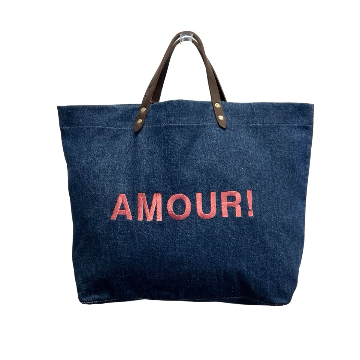 Bestickte Stofftasche von LABEL17 mit braunen Lederhenkeln und AMOUR Botschaft auf der Vorderseite. Hergestellt in Marokko