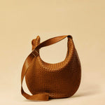 The Saddle Bag LUNA by LABEL17 is hand-braided from the finest vegetable-tanned nappa leather. Its softly curved saddle shape is elegantly defined by a delicate piped seam, allowing it to rest comfortably against the body. It features a zip closure, a leather-lined interior, and a secure inner pocket. The adjustable strap allows for shoulder or crossbody wear – a versatile companion for every day. Handmade in Morocco.